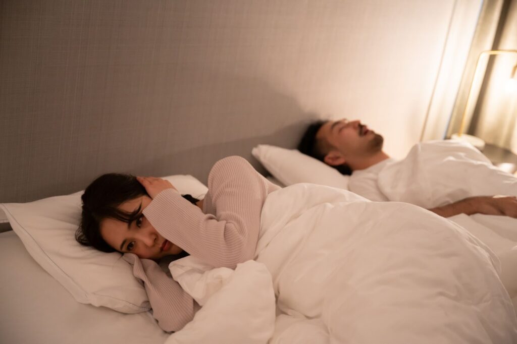 隣の男性のいびきで眠れない女性